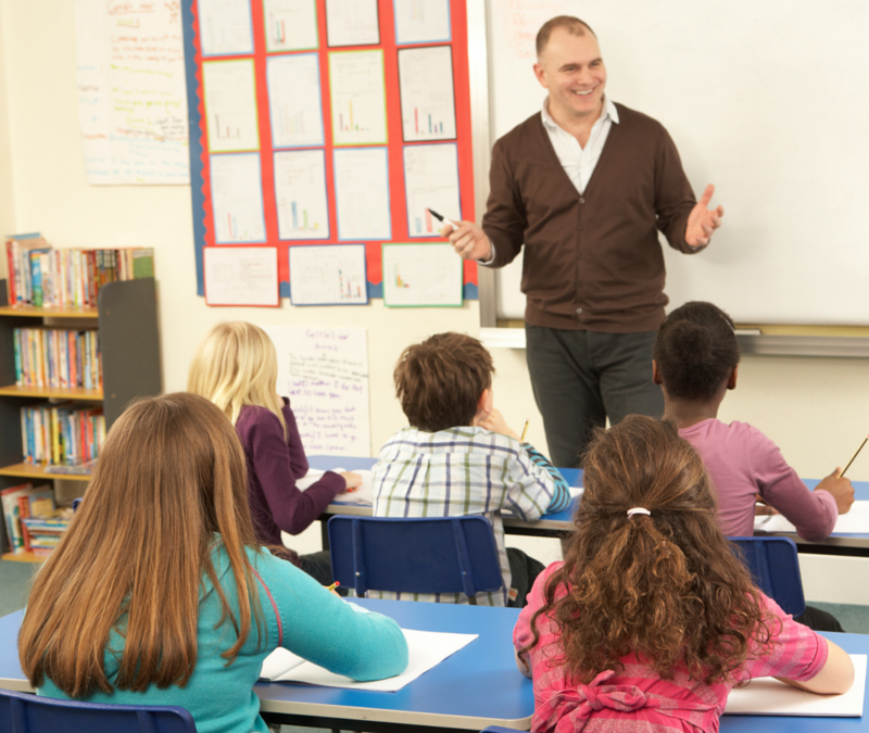 A teacher communicating with children in a classroom.