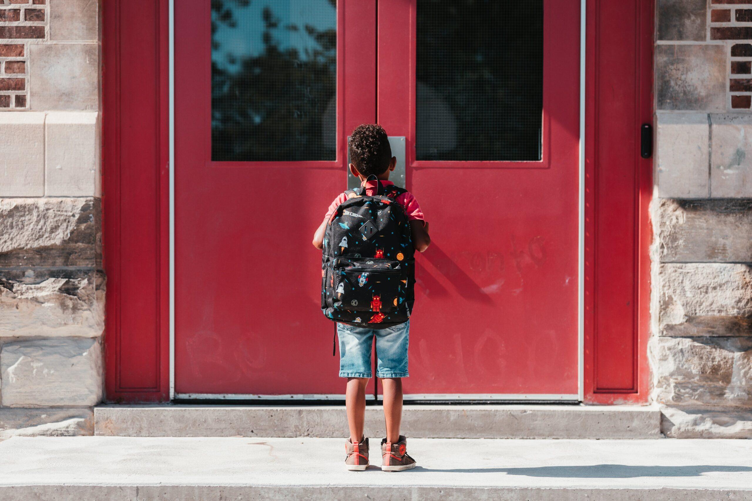 Educational Audiology, student standing in from of school